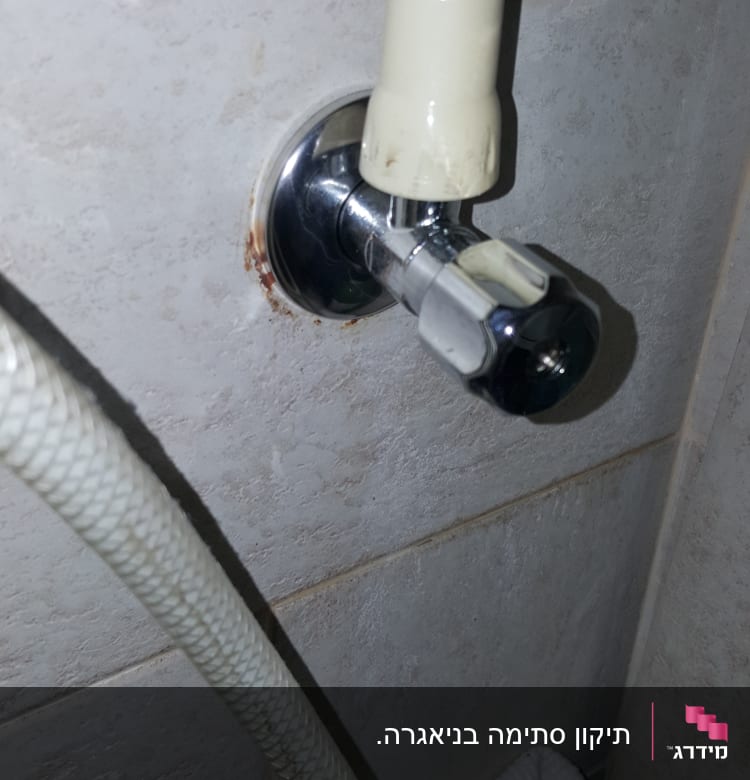 ברז מים עם צינור מחובר לקיר